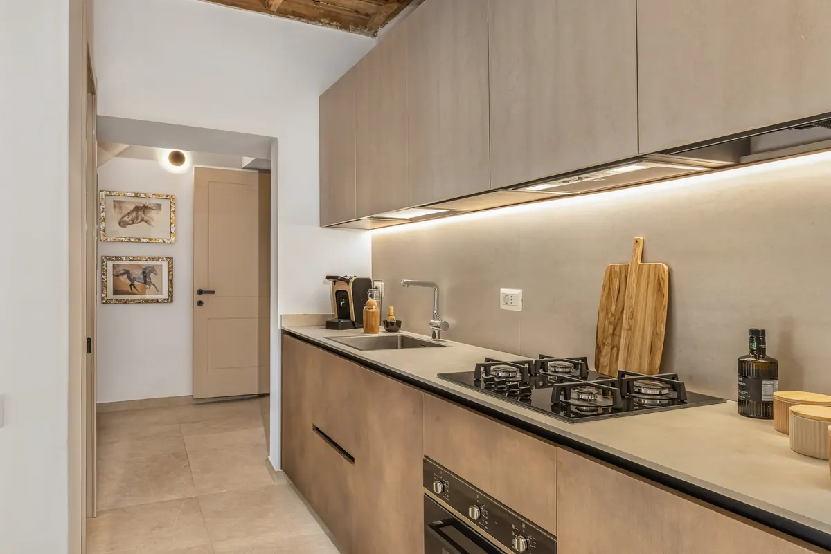 Angolo cucina con piano cottura a gas, forno e pensili in legno