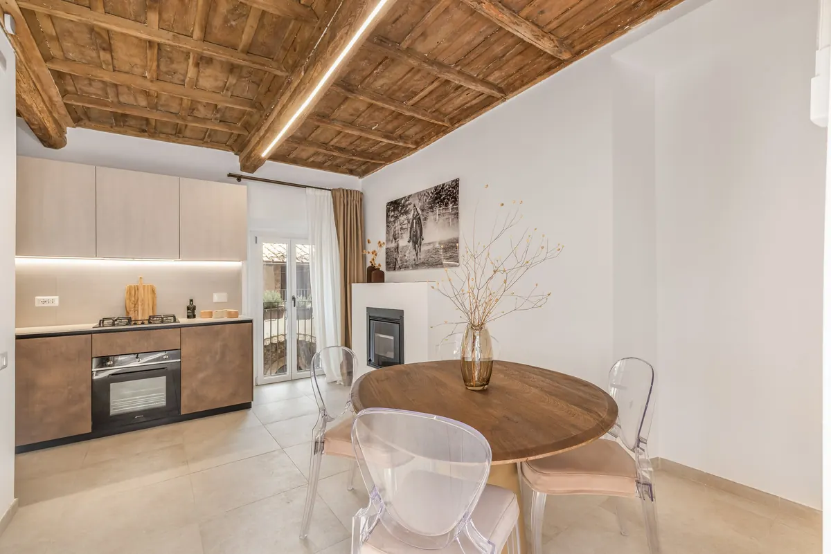Cucina e tavolo da pranzo rotondo sotto le travi a vista